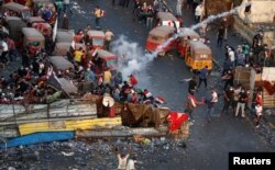 28일 이라크 바그다드에서 반정부 시위가 열린 가운데 시위참가자들이 경찰을 발포한 최루탄을 피해 흩어지고 있다.