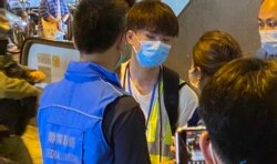 16岁中学生记者Perry7月19日下午在元朗西铁站采访7-21袭击事件一周年纪念活动，被警方传媒联络队人员截查 (美国之音/汤惠芸)