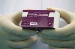 Seorang teknisi laboratorium memperlihatkan kotak obat "Remdesivir" di Eva Pharma Facility, Kairo, Mesir 25 Juni 2020. (REUTERS/Amr Abdallah Dalsh)