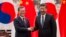 South Korean President Moon Jae-in, left, and Chinese President Xi Jinping shake hands at the end of a signing ceremony at the Great Hall of the People, in Beijing, China, Dec. 14, 2017.