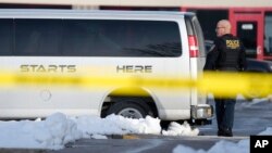 A law enforcement officer walks outside the Starts Right Here building, Jan. 23, 2023, in Des Moines, Iowa. Police say two students were killed and a teacher was injured in a shooting at the Des Moines school.
