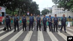 Bangladeshi police officials stand guard on a street during a general strike in Dhaka, Bangladesh, Oct. 27, 2013.