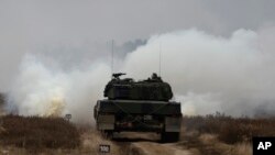 资料照片：乌克兰与波兰军人在波兰希维托舒夫一处军事基地兼试验场训练驾驶豹2坦克。(2023年2月13日)