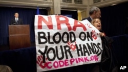 Protes ketika Ketua Asosiasi Nasional Pemilik Senapan (NRA) berpidato membela kepemilikan senjata (21/12). (AP/Evan Vucci)