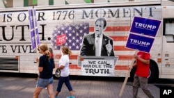 FILE - Former president Donald Trump supporters walk near the Fiserv Forum before the Republican presidential debate on Aug. 22, 2023, in Milwaukee.
