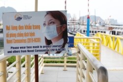 រូបឯកសារ៖ បដាស្តីអំពីវិធានការការពារខ្លួនពីជំងឺកូវីដ១៩ នៅចំណតទូកនិងនាវាកម្សាន្តក្នុងតំបន់ឆ្នេរ Ha Long នៅខេត្ត Quang Ninh ប្រទេសវៀតណាម កាលពីថ្ងៃទី១៩ ខែឧសភា ឆ្នាំ២០២០។