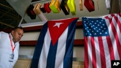 FILE - A man walks past Cuban and U.S. flags at the 33rd Havana International Fair (FIHAV) in Havana, Cuba, Nov. 2, 2015. 