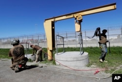 Members of the Border Patrol's Border Tunnel Entry Team work near a tunnel entrance in between two border barriers separating San Diego and Tijuana, Mexico, in San Diego, March 6, 2017.
