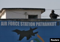 An Indian security personnel stands guard on a building at the Indian Air Force (IAF) base at Pathankot in Punjab, India, Jan. 5, 2016.