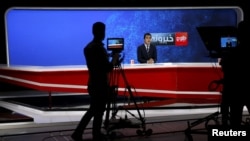 FILE - FILE - A news anchor is seen on camera during a broadcast at Tolo News studio, in Kabul, Afghanistan, Oct. 18, 2015.