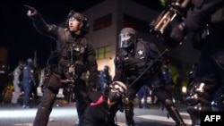 Polisi Portland dan petugas Patroli Negara Bagian Oregon bekerja sama menangkap pengunjuk rasa di depan Kantor Polisi Portland, North Precinct, 10 Agustus 2020. (Foto: dok). 