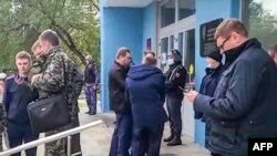 Para penyelidik di luar kampus Universitas Perm, Russia setelah penembakan, 20 September 2021. (AFP PHOTO / Investigative Committee of Russia)
