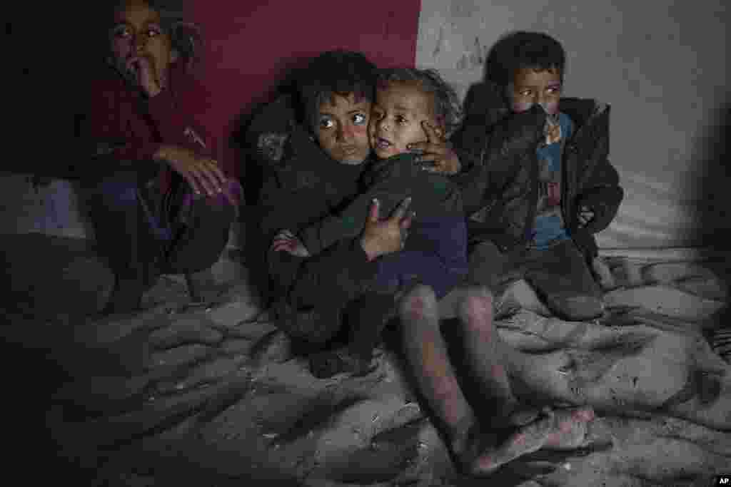 Palestinian children sit inside their family&#39;s tent at a camp for internally displaced Palestinians on the beachfront in Deir al-Balah, central Gaza Strip.
