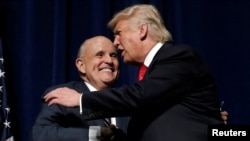 FILE - On Sept 6, 2016, Republican presidential nominee Donald Trump embraces former New York City Mayor Rudolf Giuliani at a campaign rally in Greenville, N.C.