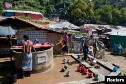 FILEL - Rohingya Muslim men collect water from a well at Unchiprang refugee camp near Cox's Bazar, in Bangladesh, Nov. 16, 2018.