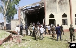 Soldiers stand guard outside St. Rita's Catholic church following a suicide bombing in Kaduna, Nigeria, Oct. 28, 2012.