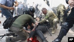 Seorang polisi Ukraina terluka akibat ledakan granat ketika terjadi bentrokan dengan para demonstran di Kyiv, Senin (31/8).