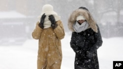 FILE – Pedestrians bundle up in Boston, Massachusetts, in January. An unusually rough winter helped depress the U.S. economy in the first quarter of 2015.