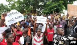 FILE - People hold placards reading "Free Ras Bath", a young radio presenter Mohamed Youssouf Bathily also known as "Rasbath" who had been arrested, as they take part in a demonstration in front of Bamako's court, Aug. 17, 2016.