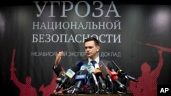 Russian opposition activist Ilya Yashin speaks while presenting a report on Chechen leader Ramzan Kadyrov, in Moscow, Feb. 23, 2016. The banner behind him reads: "National Security Threat." 