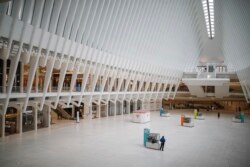 A pedestrian stands along in a sparsely populated transit hub in the downtown financial district as retail stores remain shuttered due to COVID-19 concerns, Saturday, March 21, 2020, in New York. New York Gov. Andrew Cuomo announced sweeping orders.
