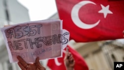 A group of Turks protest outside the Dutch consulate in Istanbul, Sunday, March 12, 2017. 