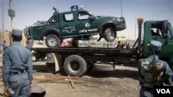 Sebuah mobil polisi yang rusak akibat serangan bom bunuh diri di Lashkar Gah, Propinsi Helmad, Afghanistan (27/9).