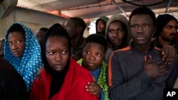 Migrants aboard the Golfo Azurro rescue vessel wait to be transferred to Italian authorities in Trapani harbor, on the Italian island of Sicily, Saturday, April 8, 2017.