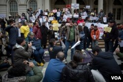 Romanian immigrant Nicolae Hent, a taxi driver and friend of Nicanor Ochisor, addresses a crowd of taxi drivers and media from the steps of New York's City Hall. (R. Taylor/VOA)