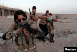 FILE - Shi'ite volunteers, who have joined the Iraqi army to fight against the predominantly Sunni militants from the radical Islamic State of Iraq and the Levant (ISIL), take part in a military-style training in Basra, Iraq.