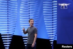 FILE - Facebook CEO Mark Zuckerberg looks at a flying drone on stage during the Facebook F8 conference in San Francisco, California.