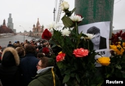 People gather at the site where Boris Nemtsov was recently murdered, with St. Basil's Cathedral and the Kremlin seen in the background, in central Moscow, Feb. 28, 2015.