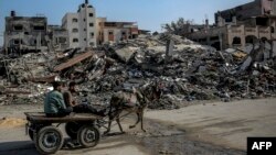 ชายชาวปาเลสไตน์นั่งรถลากโดยลาผ่านซากอาคารที่ถูกทำลายโดยการโจมตีของอิสราเอลในเมือง เบอิต ลาเฮีย ทางเหนือของกาซ่า เมื่อวันที่ 26 ก.พ. 2567 (Photo by AFP)