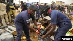Des agents de sécurité assistent les victimes d'une explosion à Sabon Gari, Kano, Nigeria, 24 juillet 2014