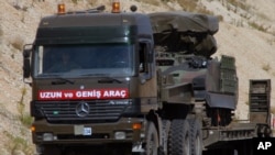 FILE - A Turkish military truck is seen transporting a mobile missile launcher to the Syrian border, near Kilis, Turkey.