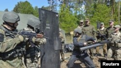 Ukrainian soldiers and servicemen of the U.S. Army's 173rd Airborne Brigade Combat Team take part in a joint military exercises in Yavoriv, outside Lviv, Ukraine, May 12, 2015.