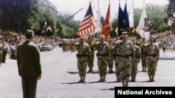 资料照片：时任美国总统乔治·H·W·布什在华盛顿问候“沙漠风暴凯旋游行”的领队H·诺曼·施瓦茨科夫将军。(1991年6月8日)