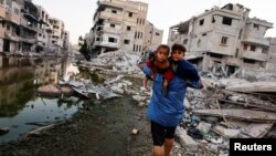 Palestinac sa dvoje dece na ulici u Kan Junisu, 3o. jun 2024. (Foto: Reuters/Mohammed Salem)