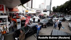 Mobil-mobil antri untuk mengisi bensin akibat mogoknya para supir truk yang terus berlanjut dan menyebabkan kelangkaan BBM di Curitiba, Brazil (26/5). 