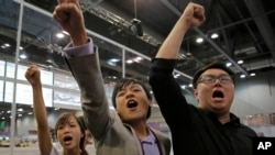 Radical activist candidates from Youngspiration group, from left, Yau Wai-ching, Kenny Wong and Henry Wong shout slogans as they celebrate after Yau won the legislative council election in Hong Kong, Monday, Sept. 5, 2016.