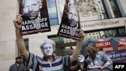 Supporters of WikiLeaks founder Julian Assange hold placards and a banners in protest outside Westminster Magistrates Court in London on May 30, 2019. 
