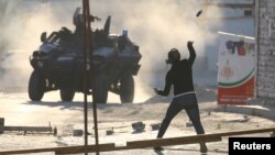 FILE - A protester throws a bottle at riot police during anti-government clashes in the Bahrainian village of Sitra, Feb. 14, 2016. A new Amnesty International report says rights violations persist in the kingdom. 