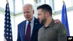 Presiden Joe Biden, kiri, berjalan bersama Presiden Ukraina Volodymyr Zelenskyy pada KTT G7 di Hiroshima, Jepang, Minggu, 21 Mei 2023. (Foto: AP)