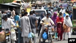 Warga Pakistan berbelanja di sebuah pasar ketika pemerintah melonggarkan locdown Covid-19 di Lahore, Minggu (17/5). 