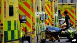Seorang pasien didorong dengan troli setibanya di luar Rumah Sakit Royal London, Whitechapel, London timur, dengan ambulans, Kamis, 6 Januari 2022.