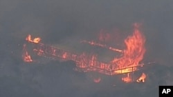 This image made from video shows a house on fire from a bushfire, Dec. 23, 2019, in Gumeracha, South Australia.
