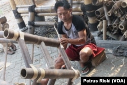 Salah satu pekerja di Bambu Indah Craft Trenggalek mengerjakan kursi dari bambu. (Foto: VOA/Petrus Riski).