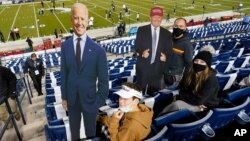 អ្នកទស្សនាការប្រកួតកីឡាបាល់ឱបរបស់អាមេរិក កាន់បដារូបបេក្ខជនប្រធានាធិបតីលោក Donald Trump និងលោក Joe Biden នៅទីក្រុង Provo រដ្ឋ Utah កាលពីថ្ងៃទី៣១ ខែតុលា ឆ្នាំ២០២០។