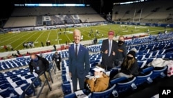 Para penggemar klub sepak bola Amerika, BYU, membuat poster gambar capres Demokrat Joe Biden dan petahana Presiden Donald Trump sebelum laga antara BYU dan Western Kentucky, di Provo, Utah, Sabtu, 31 Oktober 2020.