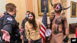 រូបឯកសារ៖ ក្រុមអ្នកគាំទ្រ​លោក Donald Trump ដោយ​រួមមាន​លោក Jacob Chansley (ស្តាំ) បាន​ប្រឈមមុខ​នឹង​ប៉ូលិស​ការពារ​​វិមាន​សភា​កាពីតូល នៅផ្នែក​ខាងក្រៅ​ព្រឹទ្ធសភា​នៅ​ខាងក្នុង​វិមាន​សភា​កាពីតូល ក្នុង​រដ្ឋធានី​វ៉ាស៊ីនតោន កាលពីថ្ងៃទី៦ ខែមករា ឆ្នាំ២០២១។